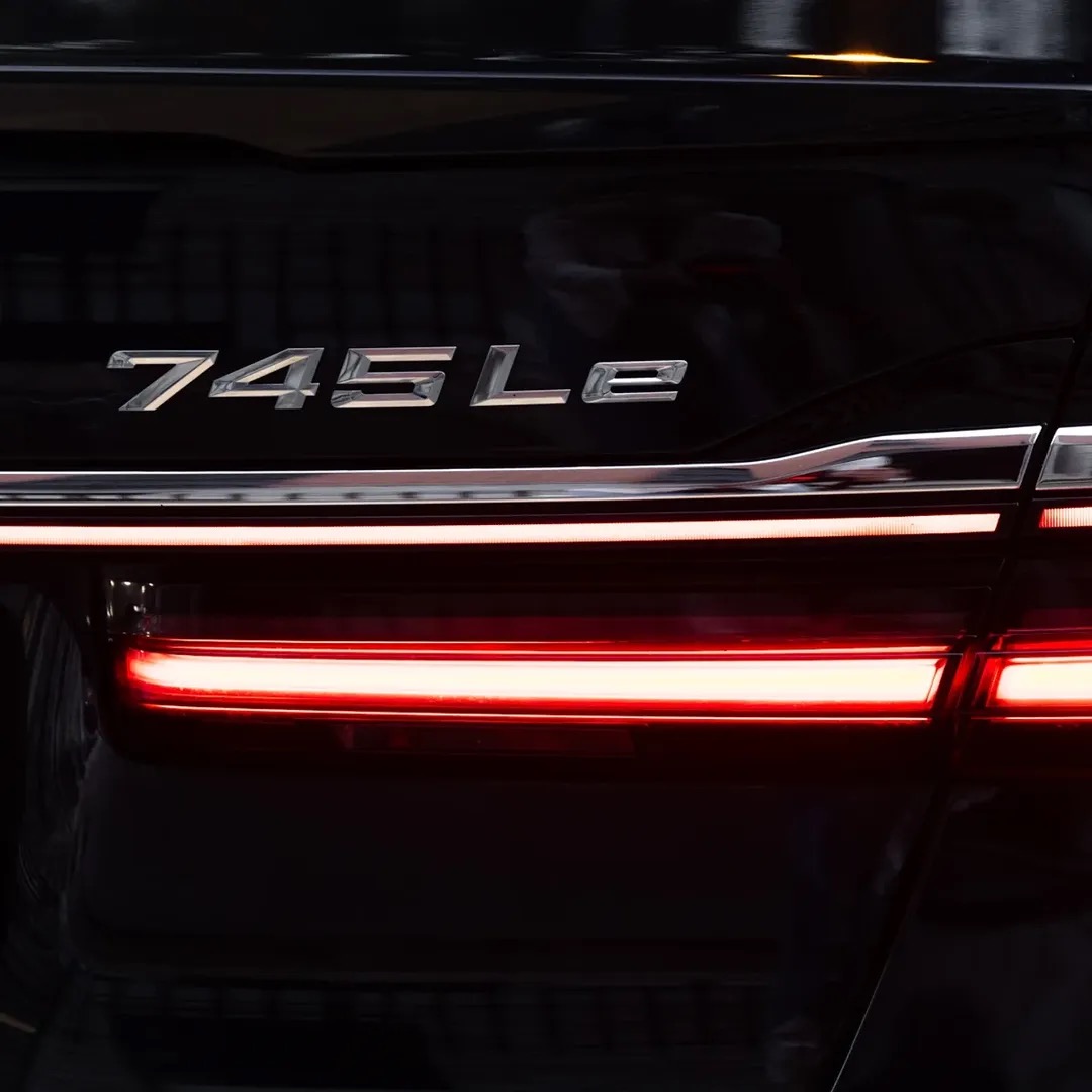 Close-up of the BMW 745Le badge and rear light on the black chauffeur car